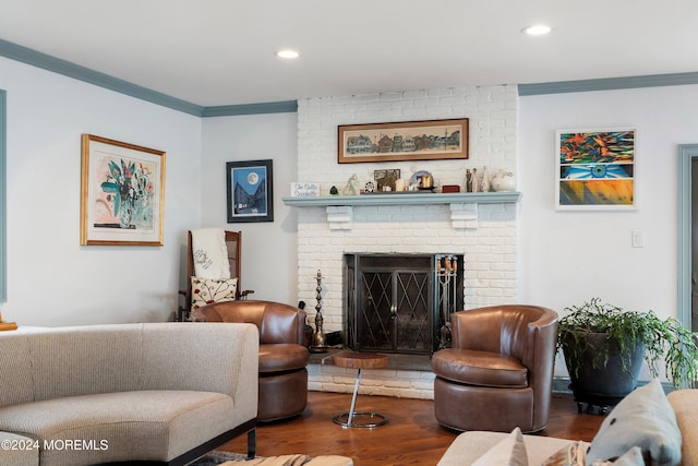 living room featuring hardwood / wood-style floors, a brick fireplace, and crown molding