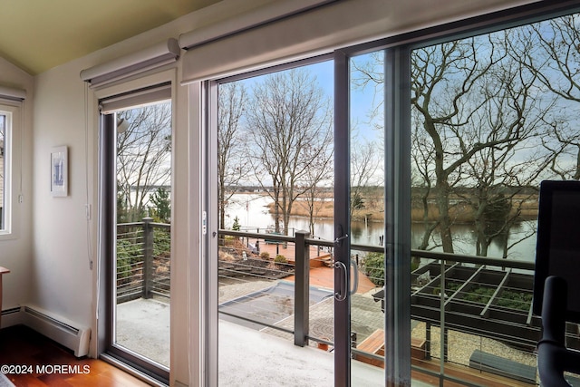 doorway with a water view, a baseboard radiator, vaulted ceiling, and hardwood / wood-style flooring