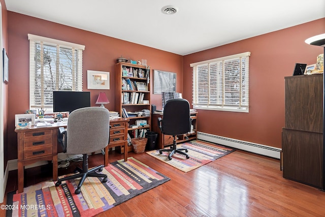 office space featuring a baseboard radiator and light hardwood / wood-style flooring