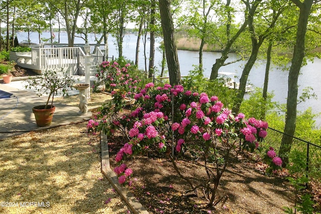 view of yard with a deck with water view