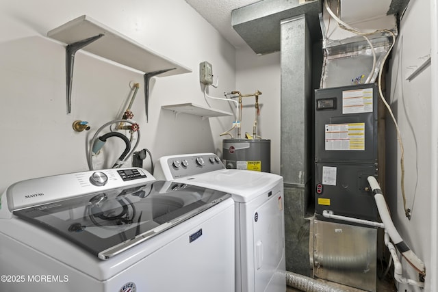 washroom featuring a textured ceiling, electric water heater, and washer and clothes dryer