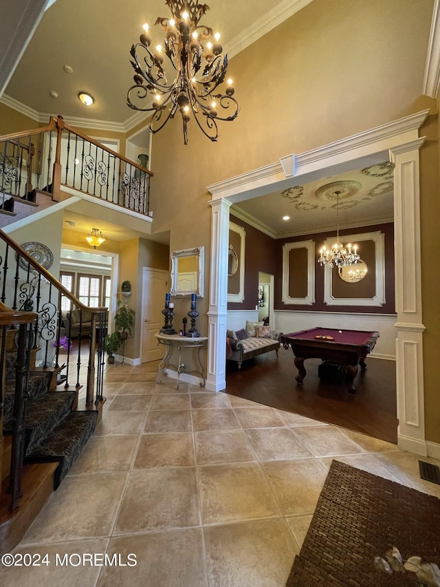 interior space featuring a high ceiling, ornate columns, crown molding, and billiards