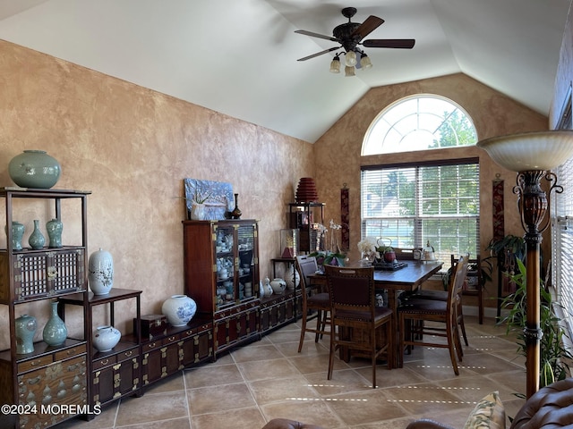 tiled dining area featuring ceiling fan and vaulted ceiling