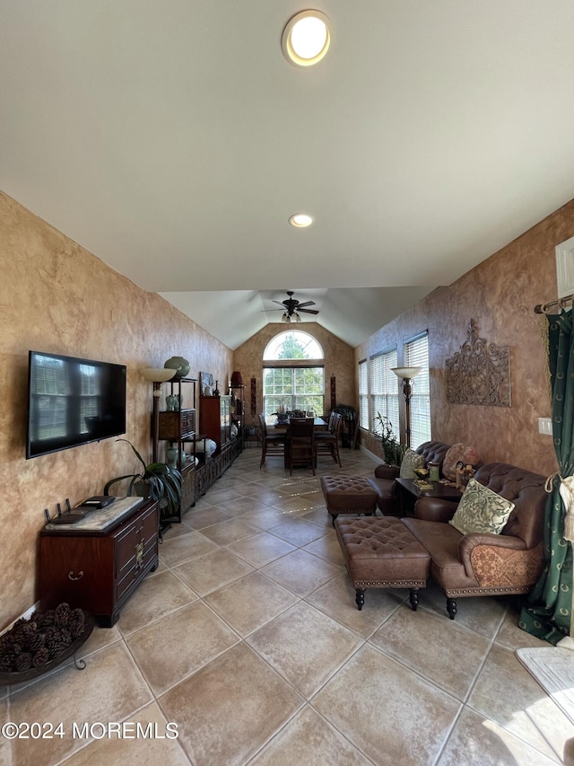 tiled living room with ceiling fan and lofted ceiling