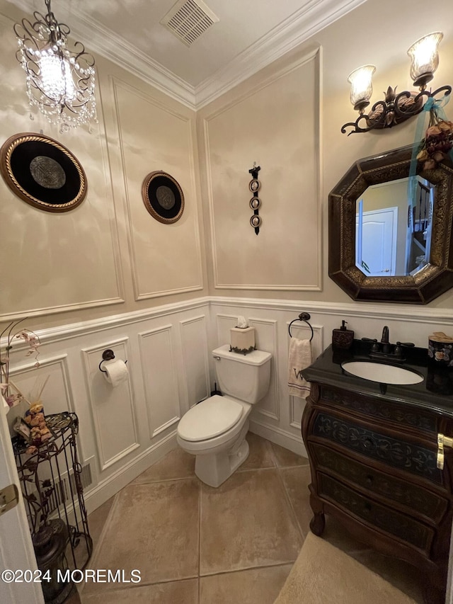 bathroom with tile patterned flooring, vanity, toilet, and crown molding