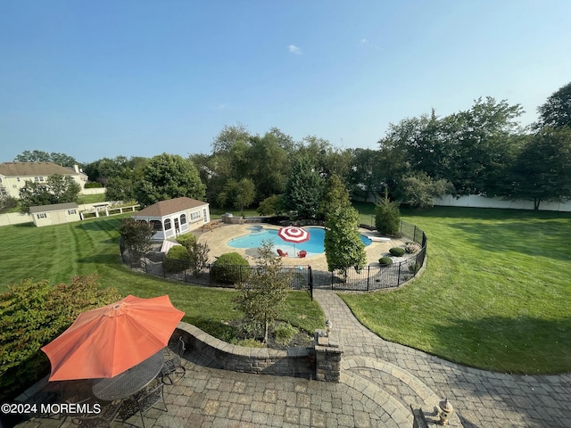 view of pool featuring a lawn, an outbuilding, and a patio