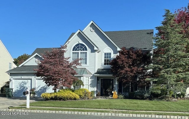 view of property featuring a garage and a front yard