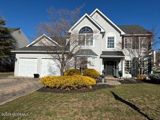 view of front of property featuring a garage and a front lawn