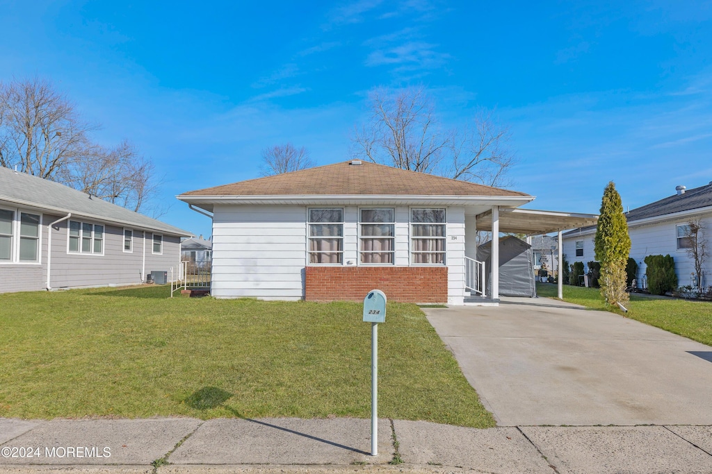 view of front of property with a carport and a front yard