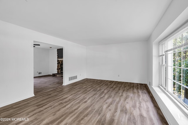 empty room featuring a fireplace, hardwood / wood-style floors, and ceiling fan