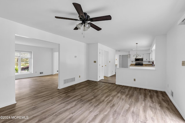 unfurnished living room featuring hardwood / wood-style flooring and ceiling fan