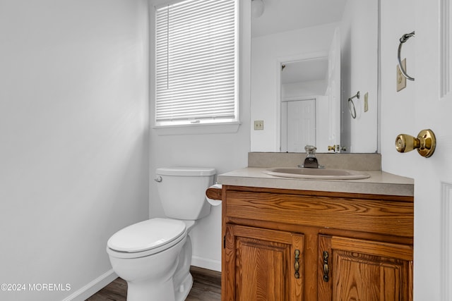 bathroom featuring vanity, hardwood / wood-style flooring, toilet, and plenty of natural light