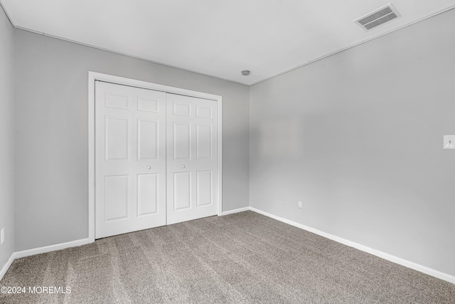 unfurnished bedroom featuring carpet and a closet