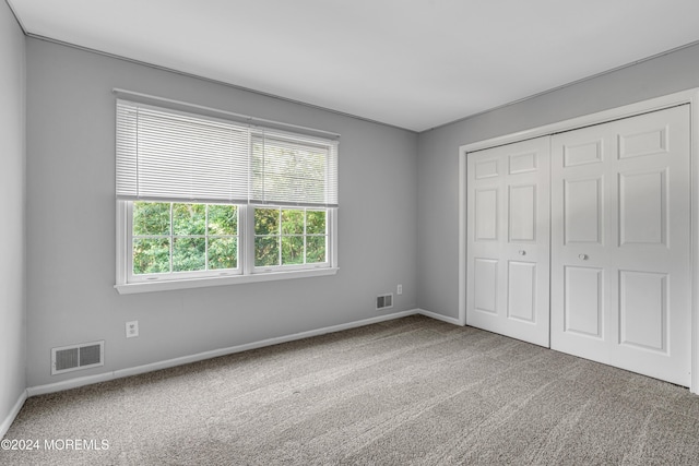 unfurnished bedroom with carpet floors and a closet