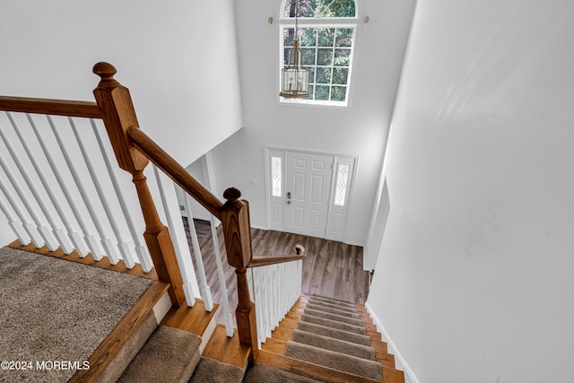 staircase featuring hardwood / wood-style floors and a high ceiling