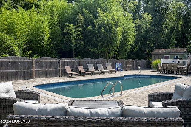 view of swimming pool with a patio area and an outbuilding