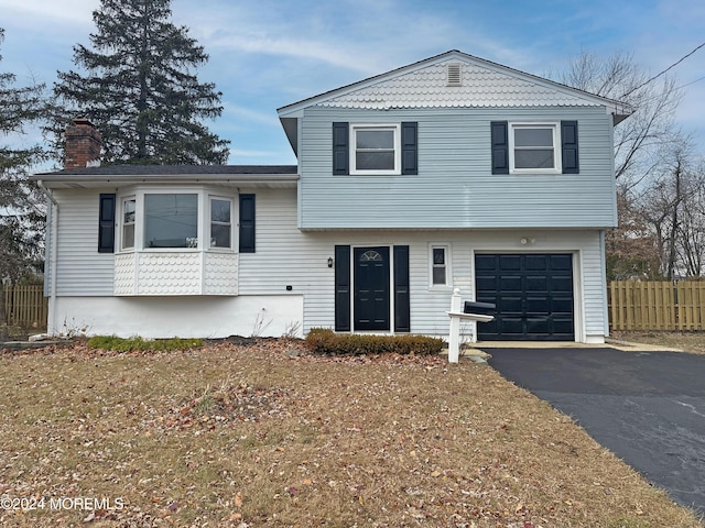 split level home with a front lawn and a garage