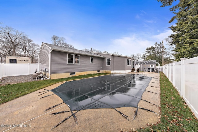 back of property featuring a patio area and a covered pool