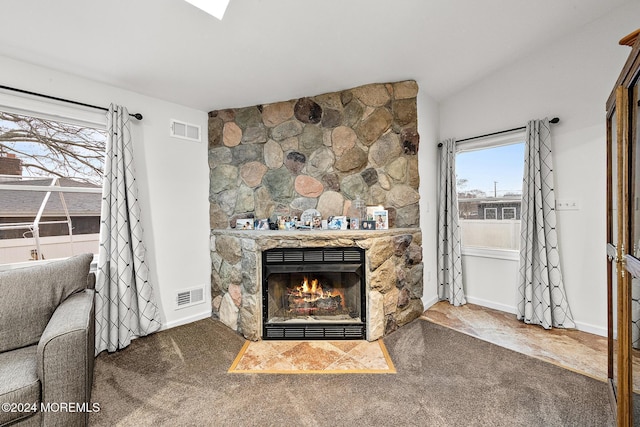 carpeted living room featuring a fireplace and vaulted ceiling