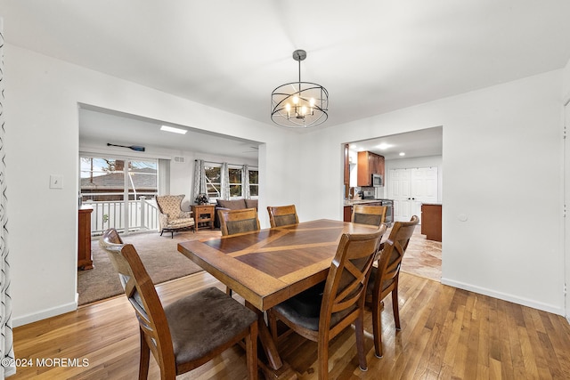 dining area featuring light hardwood / wood-style flooring and an inviting chandelier