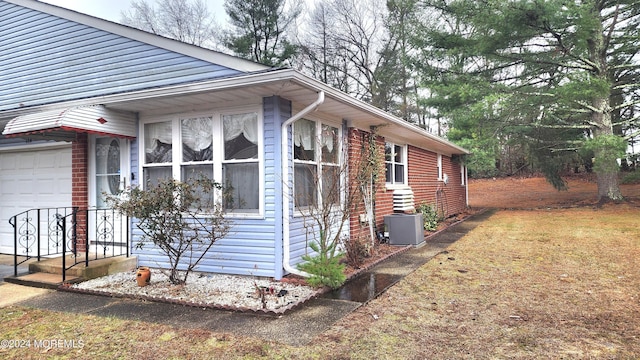 view of side of home featuring a garage and central AC unit