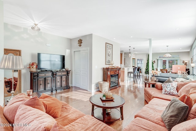 living room featuring a notable chandelier and light wood-type flooring