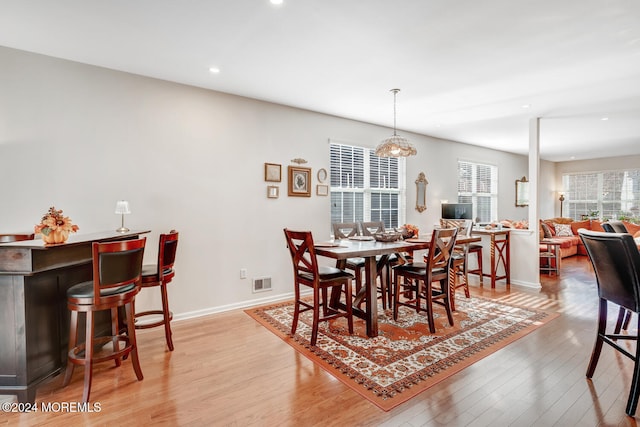 dining area featuring an inviting chandelier and light hardwood / wood-style flooring