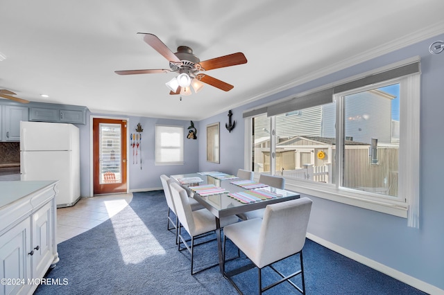 dining room featuring ceiling fan, light carpet, and ornamental molding