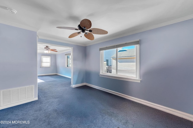 unfurnished room with dark colored carpet, ceiling fan, and crown molding