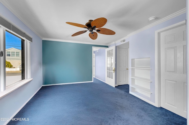 empty room with dark colored carpet, ceiling fan, and ornamental molding