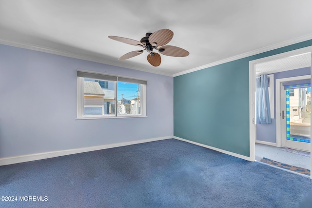 carpeted spare room featuring ceiling fan, a healthy amount of sunlight, and ornamental molding