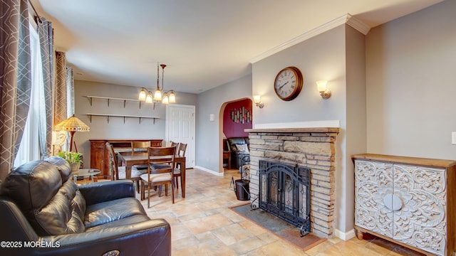 living room with a fireplace, ornamental molding, and a notable chandelier