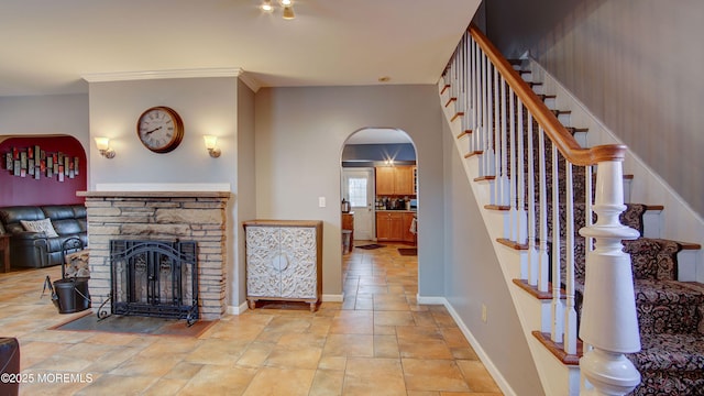 living room featuring a stone fireplace and ornamental molding