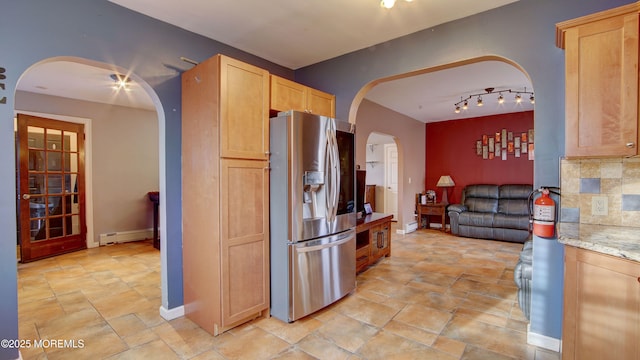 kitchen with stainless steel refrigerator with ice dispenser, a baseboard radiator, tasteful backsplash, and light brown cabinetry