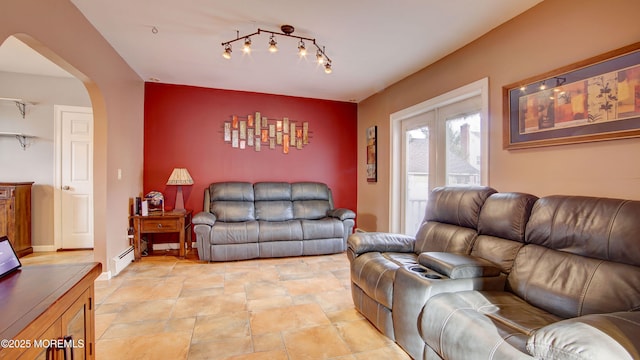 living room with a baseboard radiator and track lighting