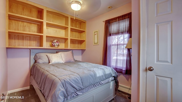 bedroom with ceiling fan, a baseboard heating unit, and dark colored carpet