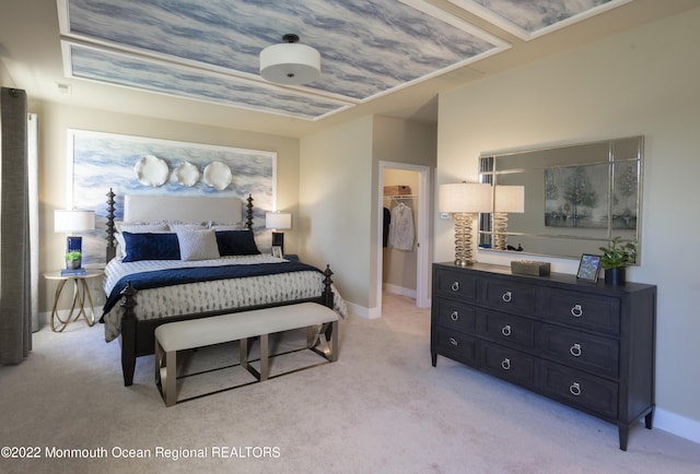 carpeted bedroom with a walk in closet and a closet