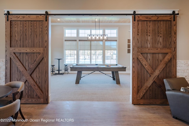 playroom featuring a barn door, hardwood / wood-style flooring, wooden ceiling, and billiards