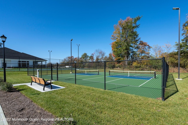 view of tennis court with a yard