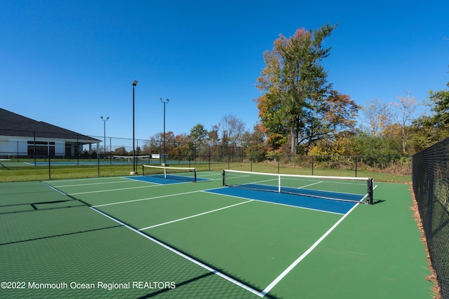 view of tennis court with basketball hoop