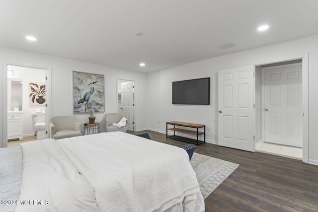 bedroom featuring ensuite bath and dark hardwood / wood-style floors