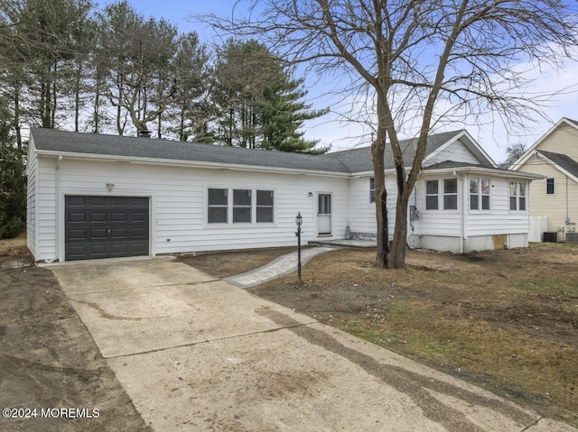 ranch-style house with a garage and central air condition unit