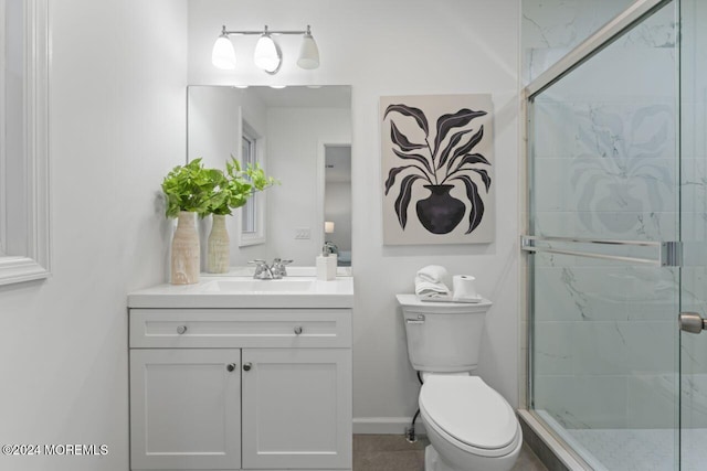 bathroom with a shower with door, vanity, and toilet