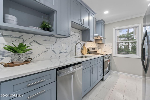 kitchen featuring decorative backsplash, light stone countertops, stainless steel appliances, crown molding, and sink