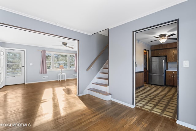 unfurnished living room with ceiling fan, dark wood-type flooring, and ornamental molding