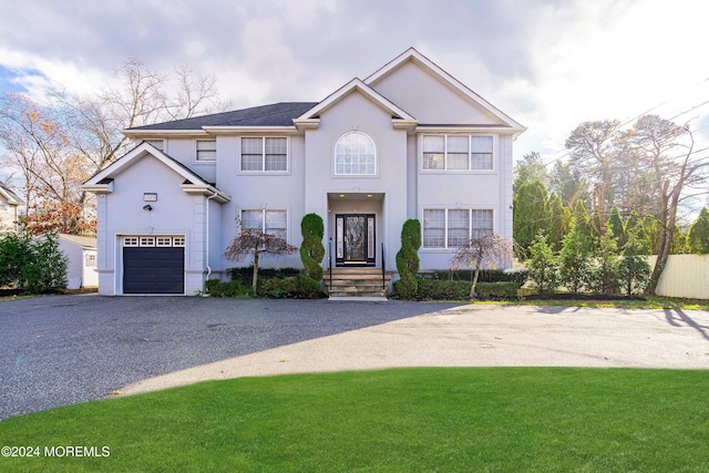 view of property with a front yard and a garage