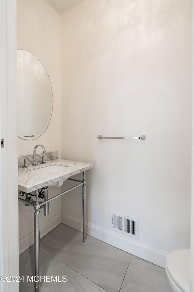 bathroom featuring concrete floors and toilet