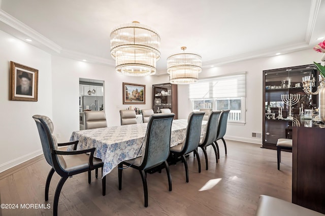 dining area with ornamental molding, hardwood / wood-style flooring, and a notable chandelier