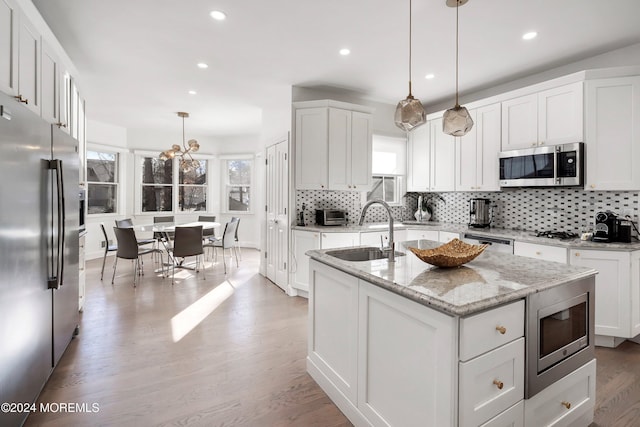 kitchen with sink, a healthy amount of sunlight, light wood-type flooring, and appliances with stainless steel finishes