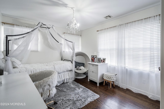 bedroom with dark hardwood / wood-style flooring and an inviting chandelier